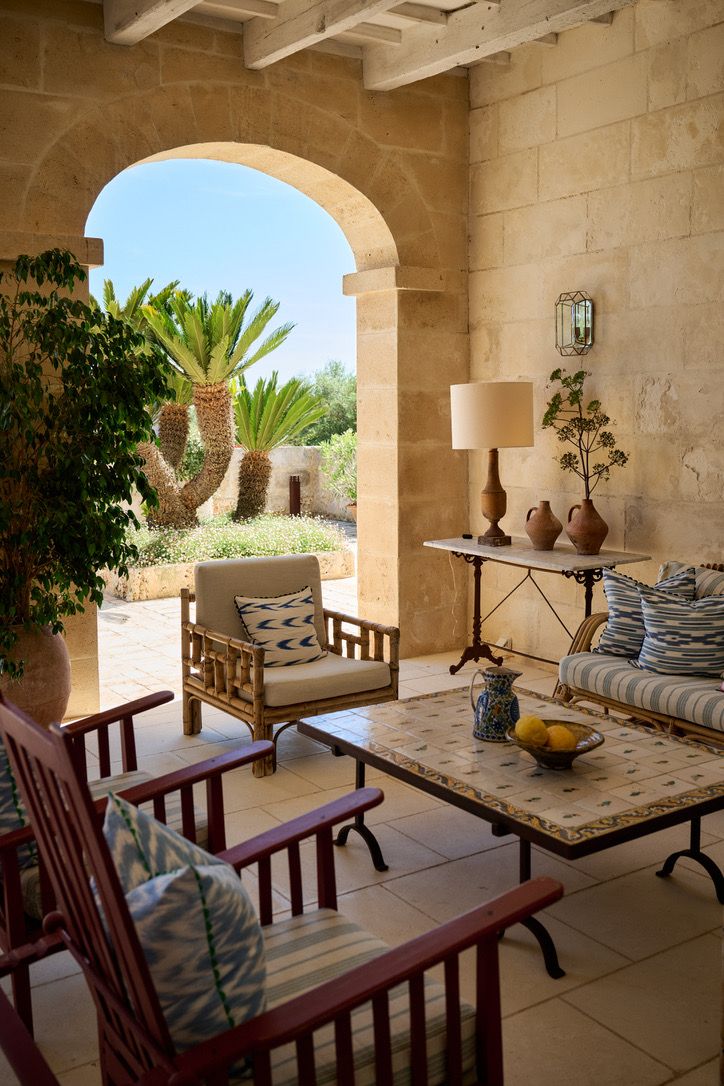 The covered loggia, its arch opening onto palms and gardens