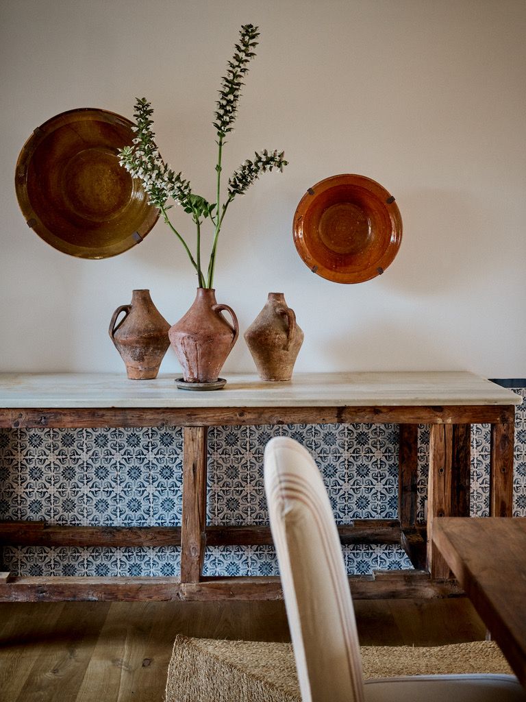 Terracotta jugs and glazed bowls on the marble-topped console