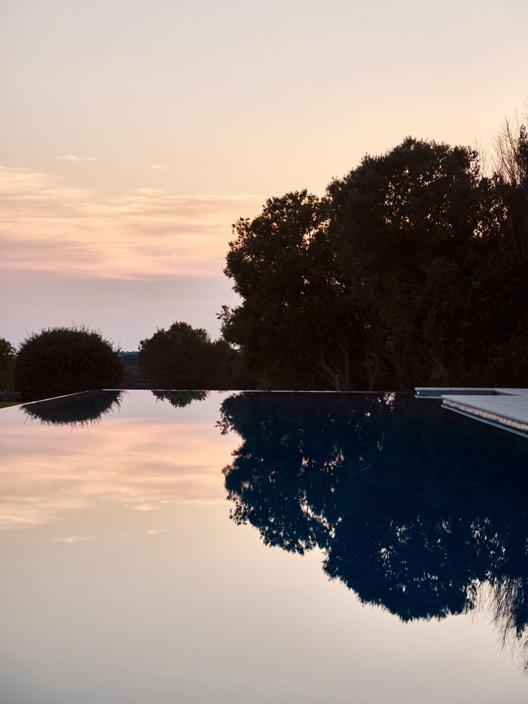 The evening sky reflected in the still water of the pool