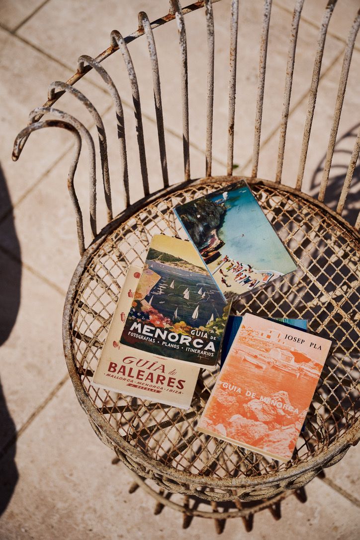 Vintage guides to Menorca on a wire chair in the sun