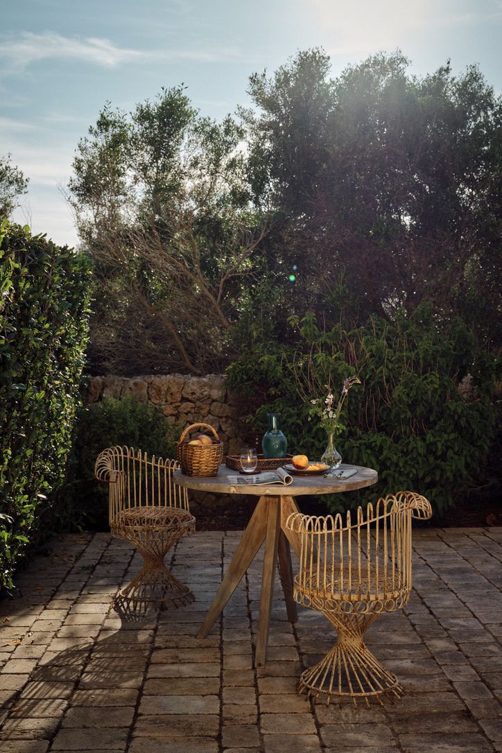 A rattan table for two in a corner of the garden